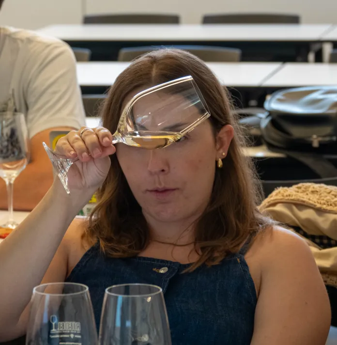Alumna observando el vino servido en una copa