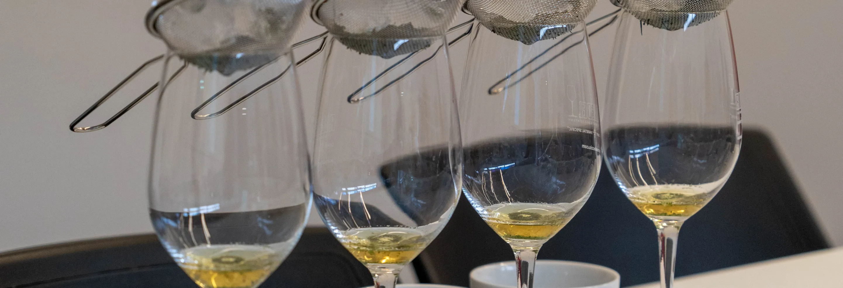 Una fila de copas de vino blanco sobre la mesa