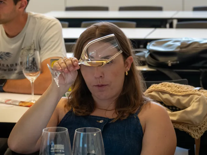 Alumna observando el vino servido en una copa