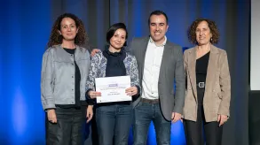 Els guanyadors posen amb el diploma del premi sobre l'escenari amb la presidenta del CETT, Maria Abellanet i la representant de la Diputació de Barcelona.