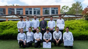 Foto de los alumnos participantes con el Cónsul en el jardín del CETT.