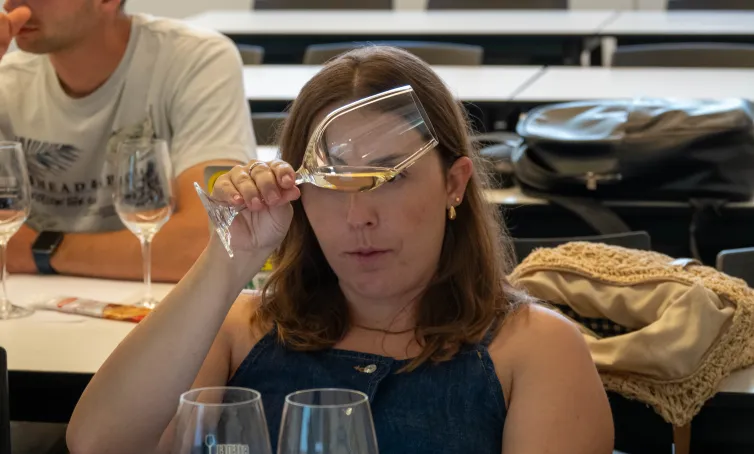 Alumna observando el vino servido en una copa