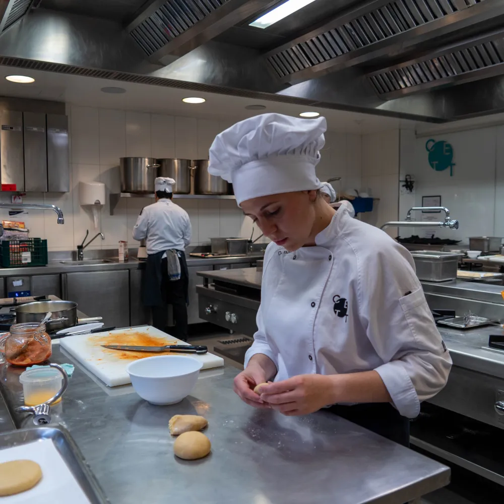 Una alumna preparando su plato en la cocina.
