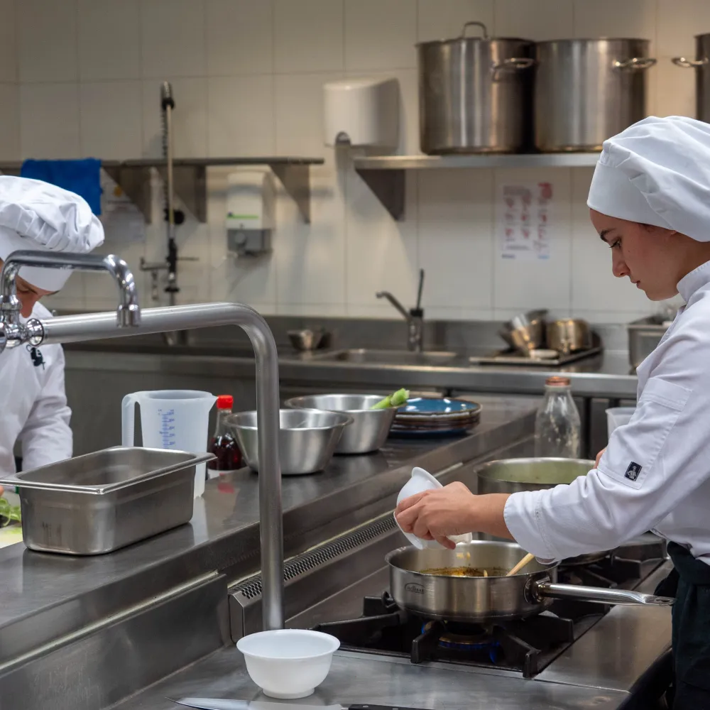 Alumnos preparando sus platos en la cocina.