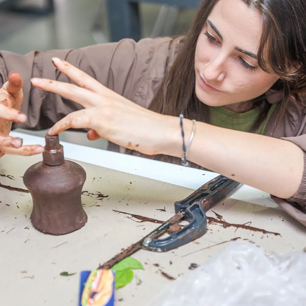 Una alumna realizando un trabajo manual con un producto de diseño. 