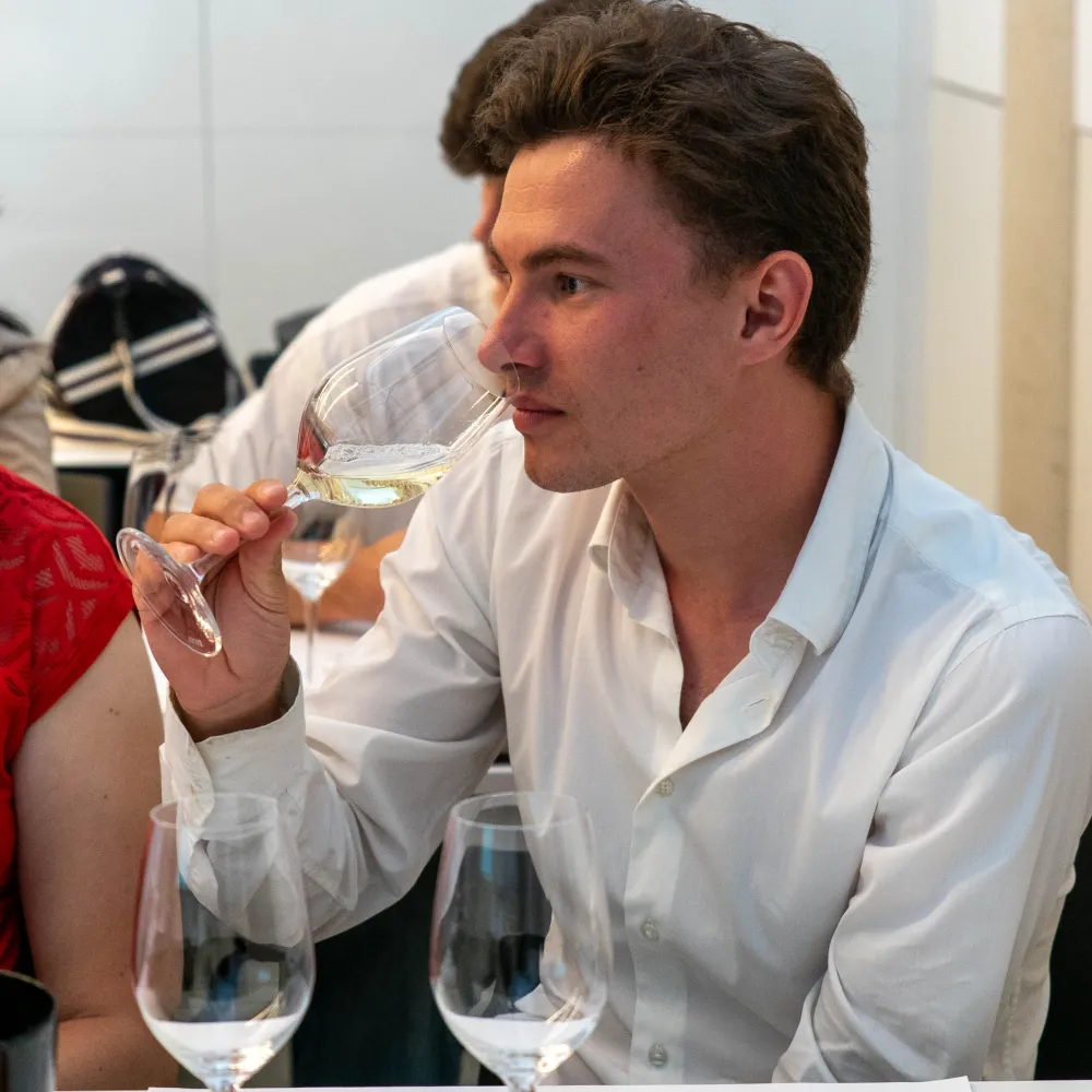Un alumno oliendo un vino blanco
