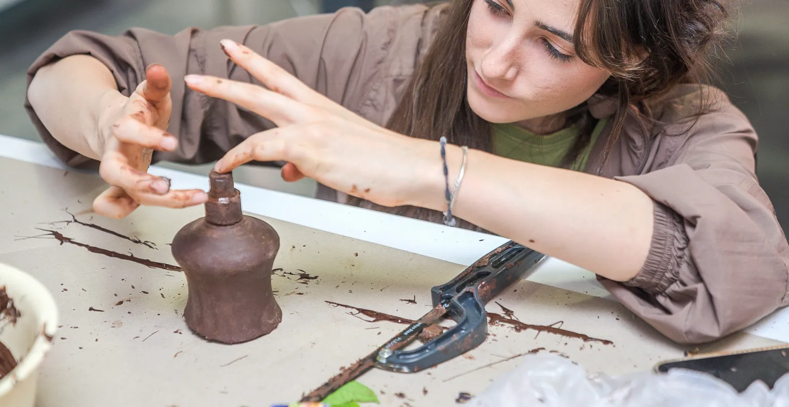 Una alumna realizando un trabajo manual con un producto de diseño. 