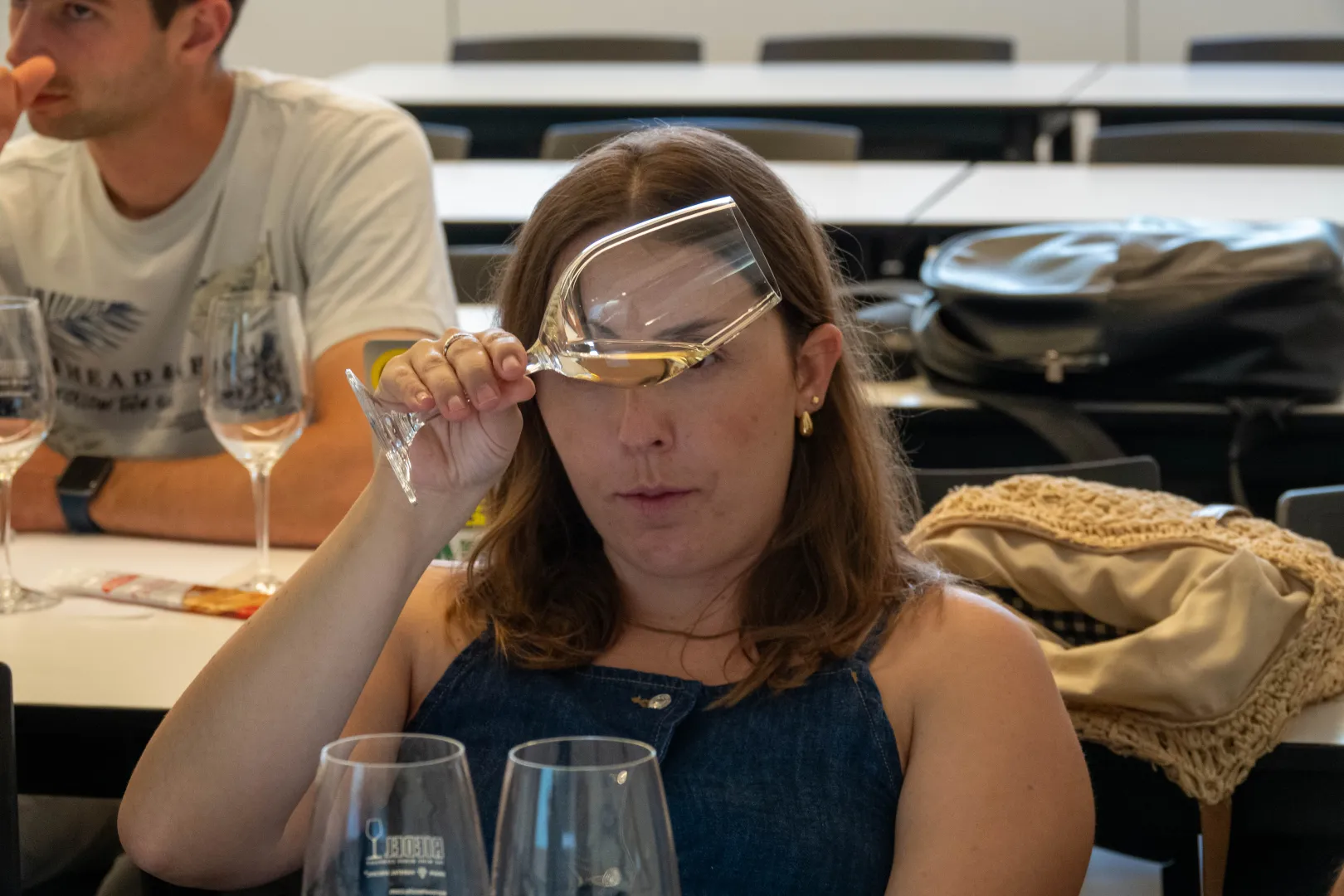 Alumna observando el vino servido en una copa