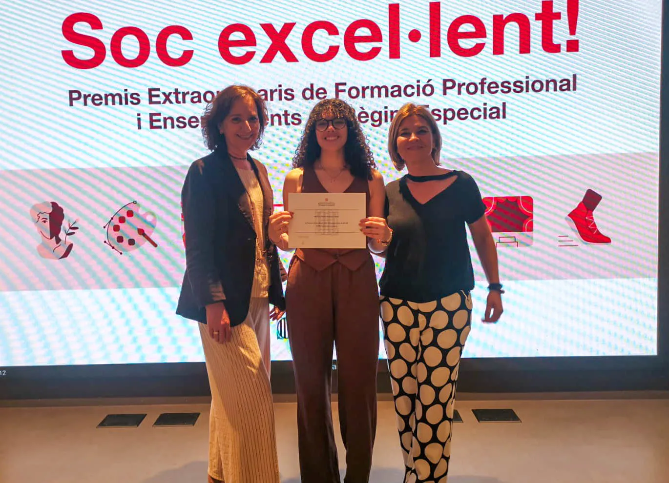 Foto de Mónica Balanza recogiendo el premio con Nan Ferreras, directora de la Escuela Técnica Universitaria, y Sílvia Puigdemassa, Coordinadora Ciclos Formativos de Grado Superior de Turismo